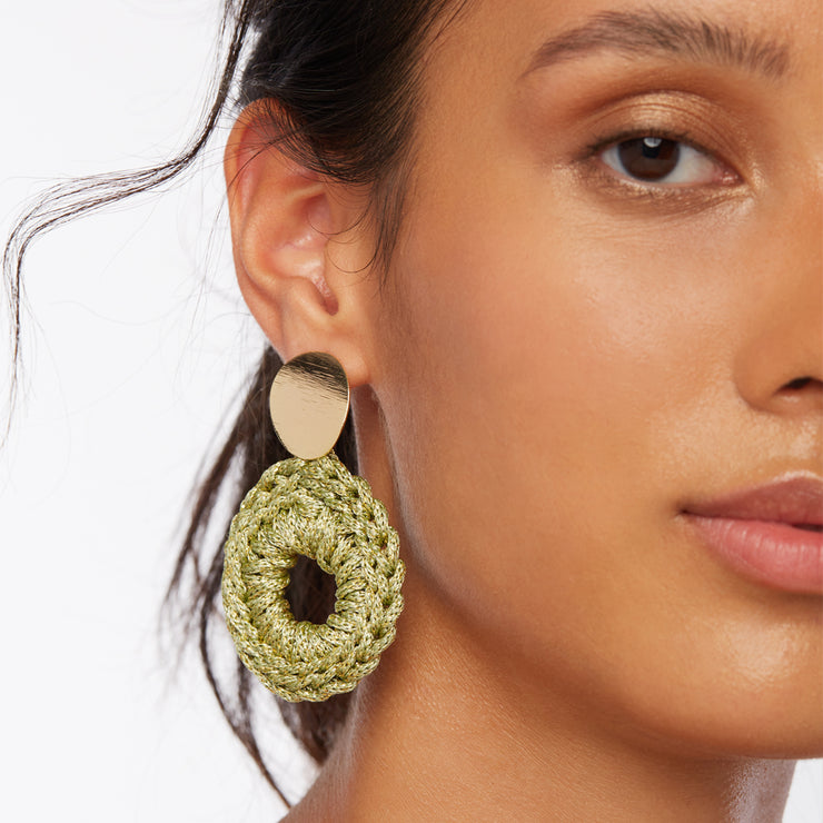 Brunette wearing a pair of medium sized lightweight front facing hoop style earrings in gold and olive green with oval gold plated posts