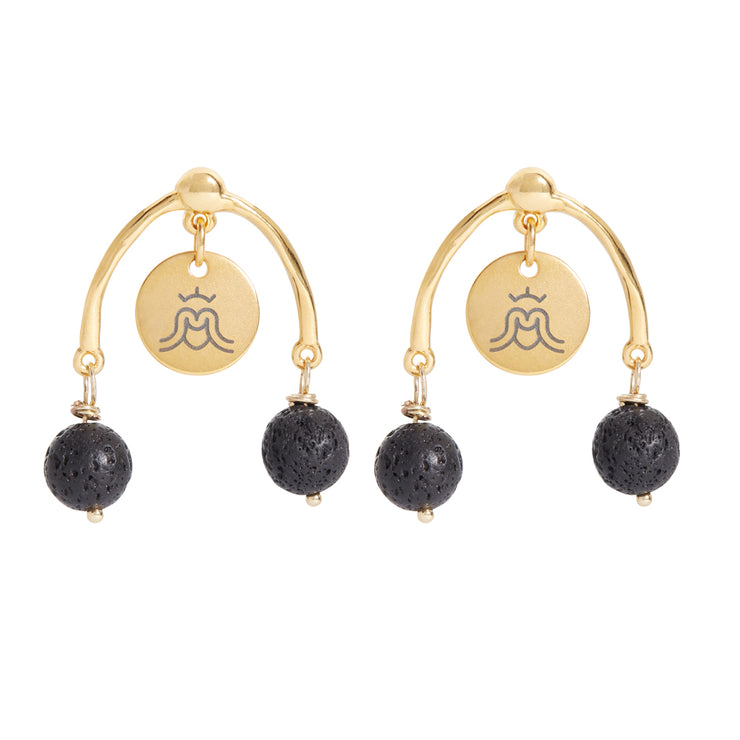 Photo of earrings in gold and black with Goddess tags . Shoe Horse style with two black lava gemstones hanging left and right and a Goddess charm in the middle