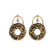 Pair of front facing hand crocheted statement hoops hanging from horseshoe-shaped earring posts in gold tones with a crystal cut glass in silver tones in the center.