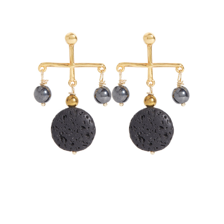 Pair of earrings in gold and black. Cross-type form with two hematite stones hanging left and right and a gold tone hematite stone with a black lava coin gemstone under it in the middle.