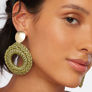 Brunette wearing a pair of hand crocheted statement front facing hoop style statement earrings in olive green and gold with oval gold plated posts