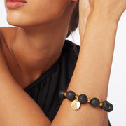 Woman's wrist wearing a  faceted hemative and black lava signature statement bracelet