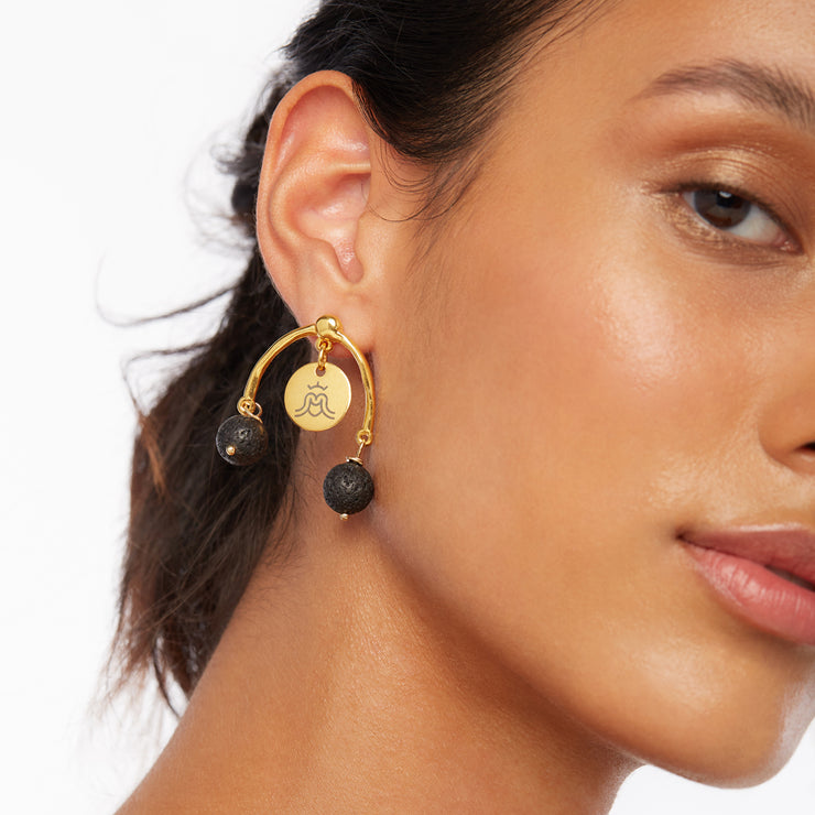 Photo of brunette girl wearing a pair of gold and black earrings